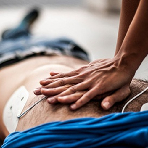 Person lying on the ground being defibrillated