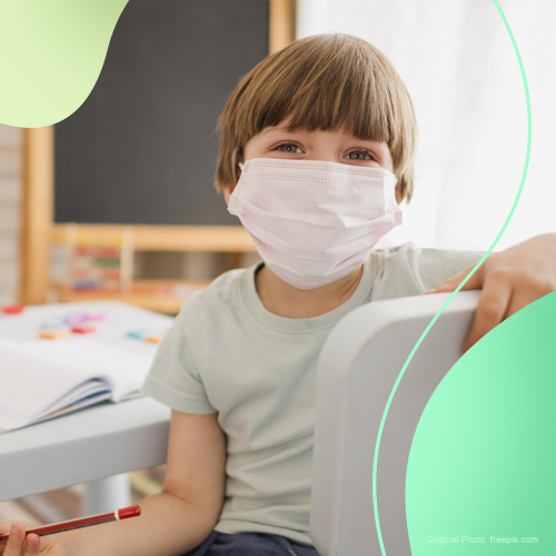 Little boy wearing a face mask while studying