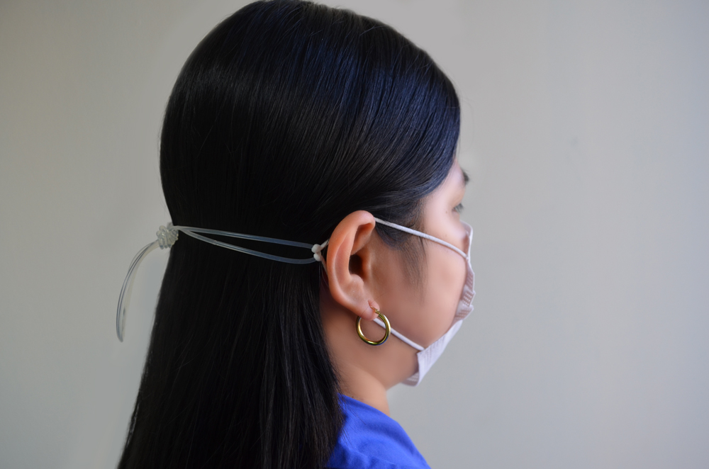 Woman wearing surgical mask with string tied at the back of her head