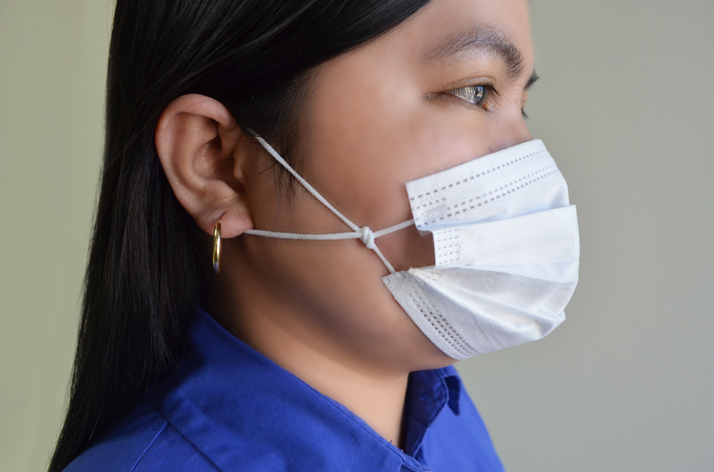 Woman wearing surgical mask with knotted ear loops